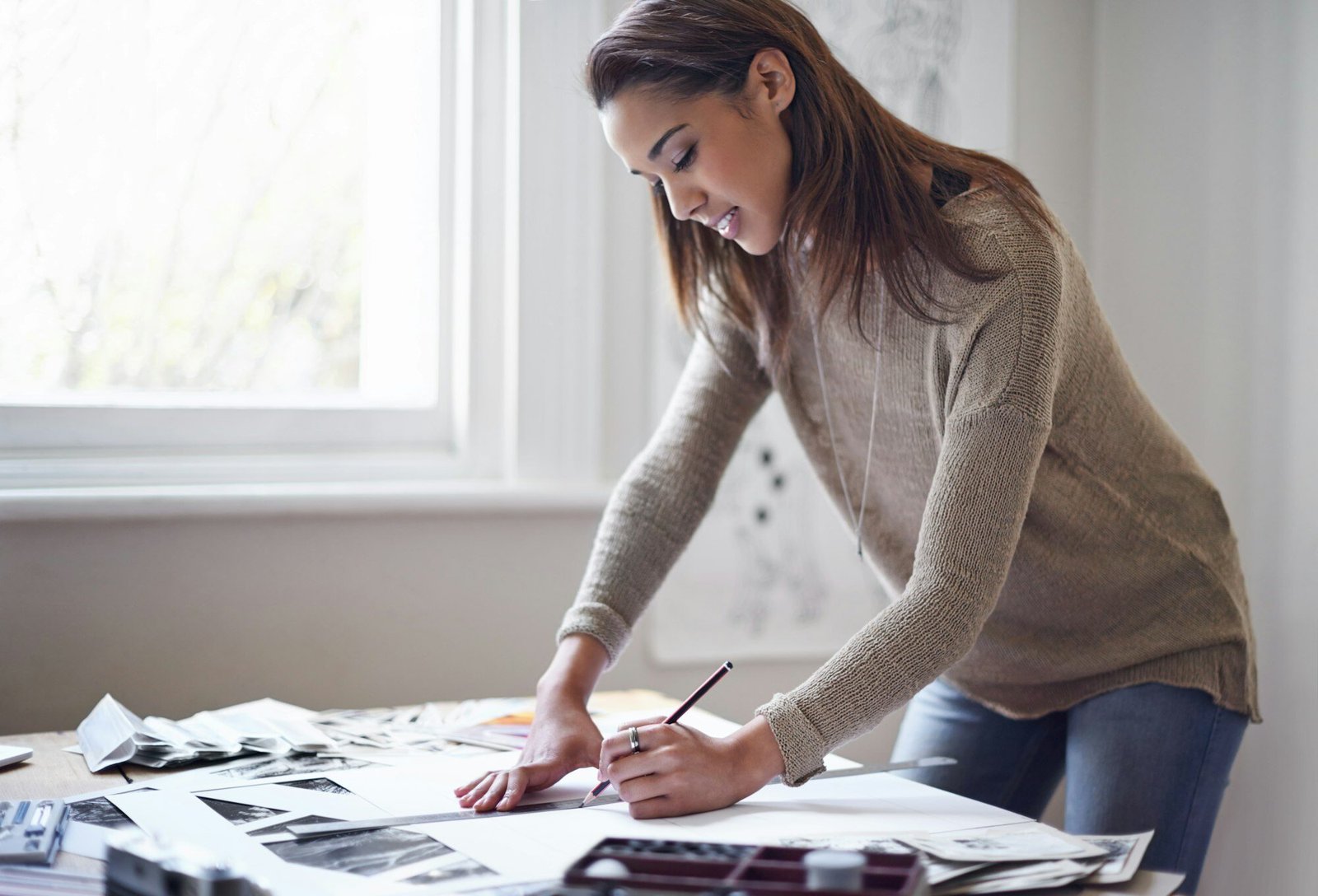 Expressing herself creatively. A young woman working on her portfolio at home.